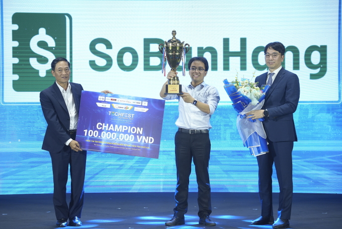 Thứ trưởng Bộ Khoa học và Công nghệ Trần Văn Tùng (trái) và Giám đốc Tập đoàn Tài chính Shinhan, ông Hyuk Choi trao bảng giải thưởng, cúp và hoa cho Quán quân cuộc thi. Ảnh: TTTT
