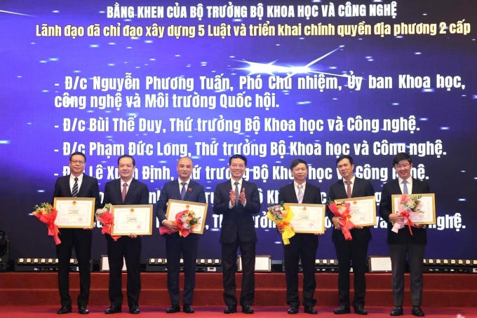Năm lãnh đạo nhận bằng khen của Bộ trưởng Khoa học và Công nghệ (người thứ tư từ bên trái) nhờ thành tích chỉ đạo xây dựng năm luật và triển khai chính quyền địa phương hai cấp. Ảnh: TTTT