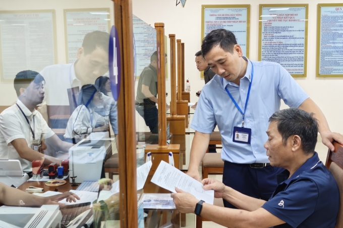 Ông Đỗ Thanh Hà, công chức Trung tâm Phục vụ hành chính công thành phố Hà Nội chi nhánh số 3 hướng dẫn người dân sử dụng dịch vụ công. Ảnh: Trọng Đạt